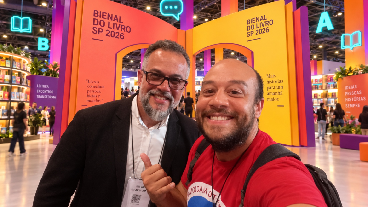 Carlos Toledo ao lado de outro autor participante diante dos portais coloridos da Bienal do Livro de São Paulo de 2026.